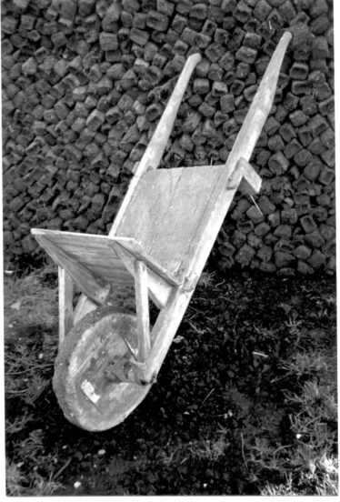 A turf barrow with a reek of turf in the background | Claregalway Parish History Pictorial (2002) CC-BY-NC-ND