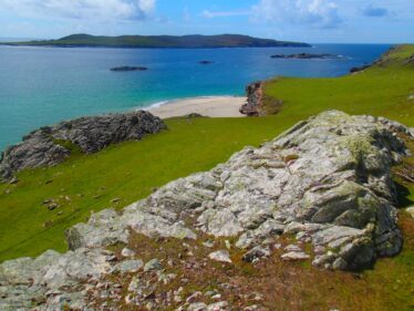 Outcrop of talcose micaceous schist (talc) on Inishbofin, with Westquarter Beach and Inishshark in the background.