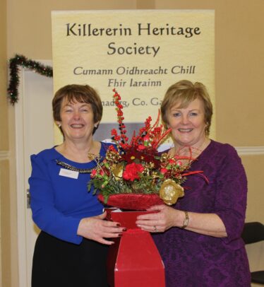 Eileen O'Connell,Secretary, (on right) presenting chairperson Bernadette Forde with an arrangement of flowers to mark the Book Launch | Source: Bernadette Connolly, Clogherboy (Barnaderg Community Centre, 18th December, 2015)