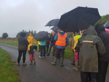 Bernie leads way along Golden Mile. People brave the weather and walk Golden Mile