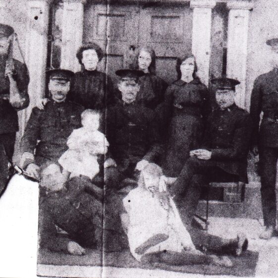 Photo-taken-outside-RIC-Barracks Photo taken outside RIC barracks. Identity of officer on either side is unknown. Back Row l-r: Mrs. Bridget Cain, her daughters Agnes and Kathleen Cain (mother of Dom Dunleavy, present owner of Barbersfort House), Front row l-r: Sergeant Dominick Keane who is holding his grandson Dominic and in front is an R.I.C. officer whose identity is also unknown with Rose Keane to the right | Killererin - A Parish History P 486