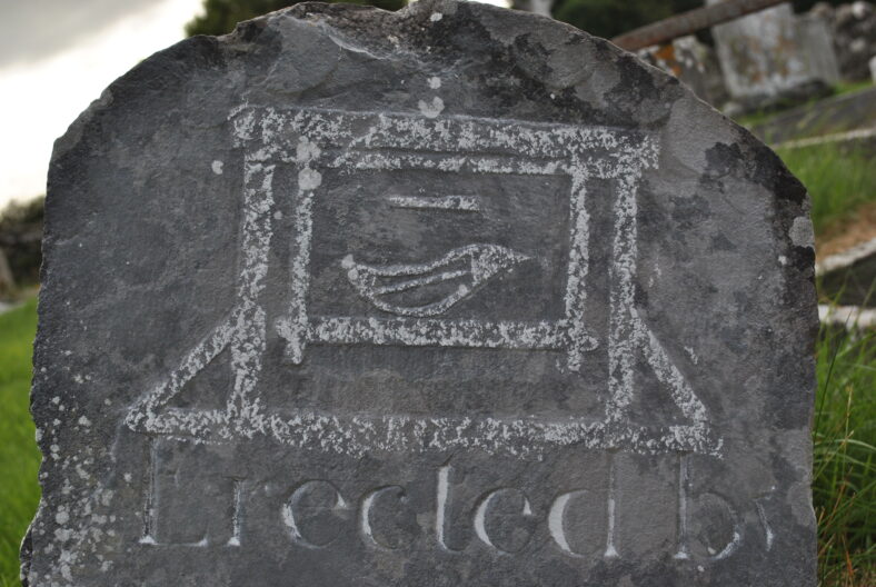 Weavers loom on a headstone.
