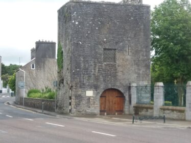 Stone gate with wooden door. Ivy growing on walls.