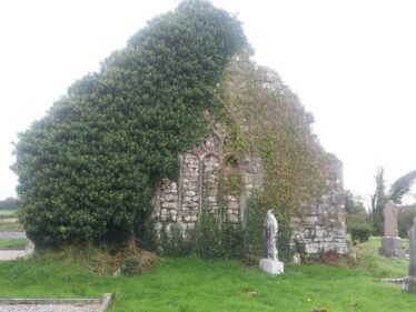 ivy covered gable partially covering tracery window
