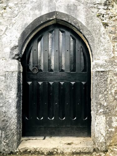 Black stained Solid timber door to six storey tower house at Aughnanure Castle, Oughterard. Within an arched opening