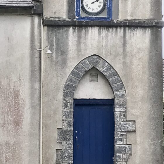 Blue rectangular door within and older stone arched door opening. | Antoinette Lydon