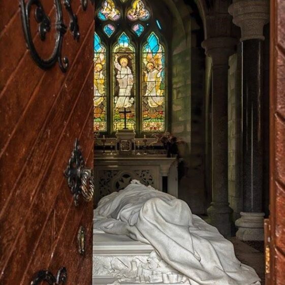 Doorway open ups to a white sheet and decorated windown within the mausoleum at Monivea | Bridie Keary, 2019