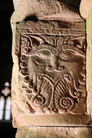 Image of a tiger/cat carved into snadstone with a curley beard and pointed ears | B. Doherty 2022