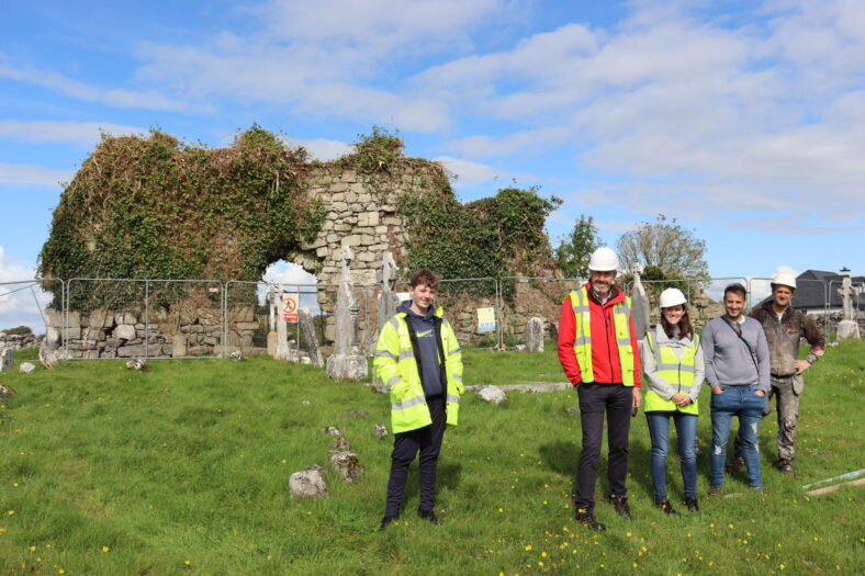 Four people standing in front of ruinous church | B. Doherty 2022