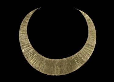 cresent shaped gold jewelery piece, with fine linese