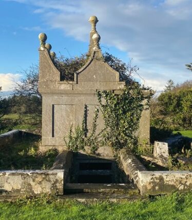 Blake mausoleum in disrepair, and partially covered with ivy