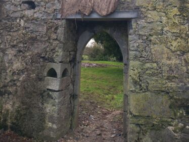 Medieval doorway at kilboght has a pointed arch and a new lintel . A foint is visible inside the doorway