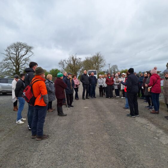 People stand in the carpark outside the gate at Abbeygormican and listen to how works came about | Marie Mannion