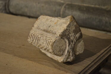 Worked piece of stone which is a gable finial, or ridge stone from a shrine, romanesque design