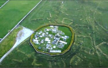Aerial view of circular graveyard enclosed by a wall and showing medieval landscape surrounding the site | Fergal Nannery