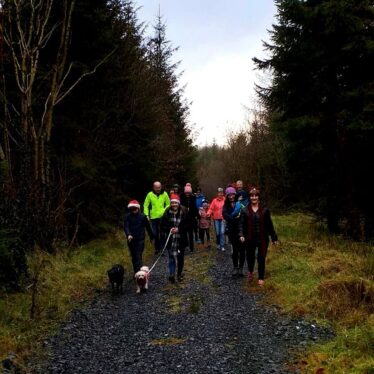 People walking in Woods wearing Santa Hats