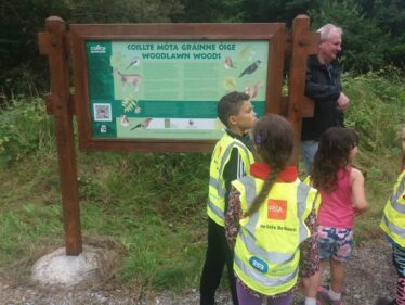 Children in Woodlawn Woods admirong the signage