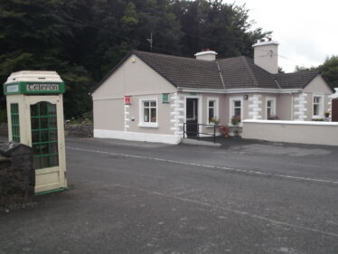 Woodlawn Post Office 2018 showing cream painted bungalow, with telephone box across the road. Once was gate house to Woodlawn House