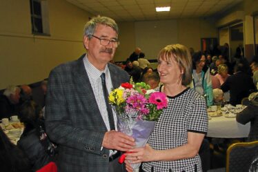 Tom Seale presents Chris Doherty with bouquet of flowers in appreciation of her service in Woodlawn Post Office
