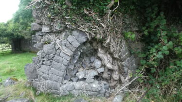 stone structure with arch filled in with rough field stone