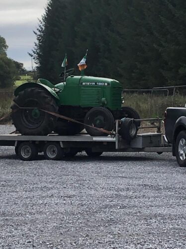 Green tractor on a trailor