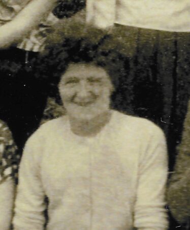 Smiling Bella Anderson, with curly hair.
