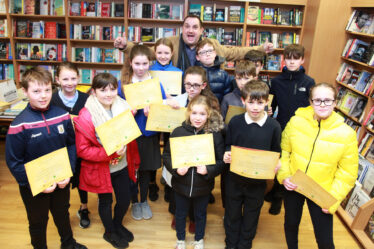 Ollie Turner launches the book "Ruaidhri's Story how Moycullen got its name" with some of the children from Moycullen who contributed to the book's illustrations