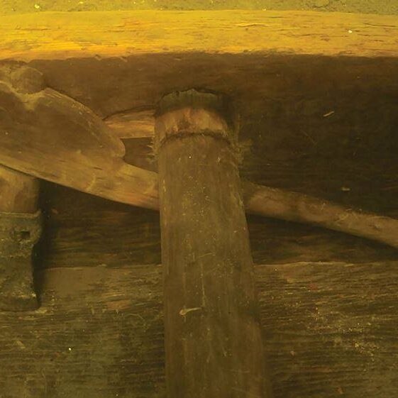 Iron Age socketed and looped iron axe still in its gracile carved, two-piece handle and fixed into position under one of two ‘seats | Photo Credit:  Karl Brady