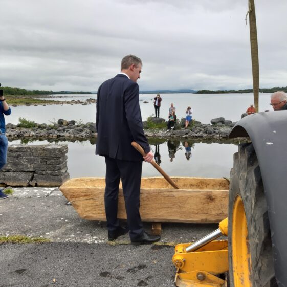 Minister Sean Kyne observes the replica Lee's Island 5 log boat before it is launched at Knockferry pier | Moycullen Heritage