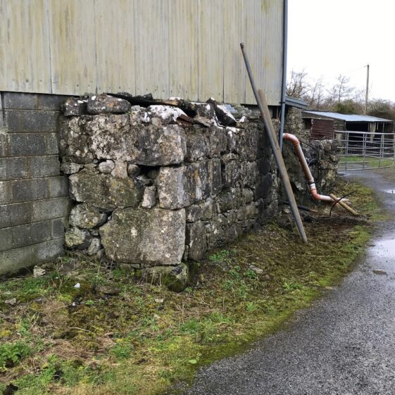 The remaining stone wall of the original Connell homestead is now incorporated into a modern farm outbuilding | Photo Courtesy John Connell