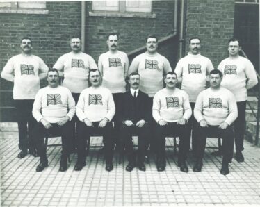 Great Britain Tug of War Team, 1912 Olympics, Stockholm Sweden. The photo appears to have been taken in the yard at Plaistow Police Station before the team left for Sweden.  Matt Hynes front row second from right. | Original Source Unknown