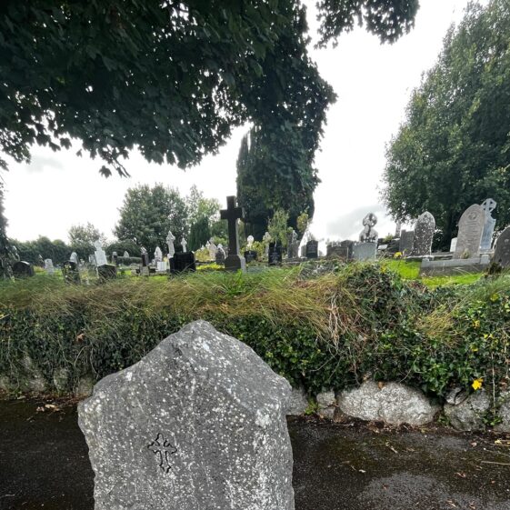 Limestone gravestone in Moycullen. While the front of the stone is carefully engraved, the back was left in its natural state revealing the brachipod at the back.