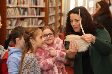 Children look closely as they are shown an owl