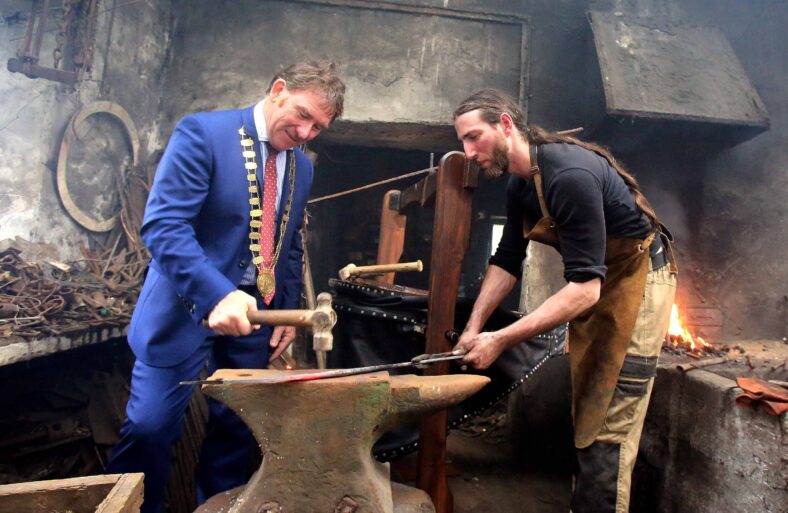 Mayor of county Galway Cllr. Peter Roche forging a sword with the help of the only sword smith in Ireland, Charlie Gallagher at the opening of the restored 