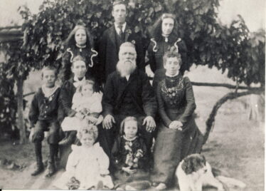 Mary (née Blackmore) and Henry Bradbury, with some of their children and grandchildren, in about 1903. (Back row, left to right)  Henrietta (later Spry); Harry (a.k.a. Henry junior); Sarah (l. Fitzgerald); (middle row) William; Mary (née Blackmore) holding baby Mabel (l. Clayton); Henry senior; Elizabeth Jennings (née Bradbury); (front row) Eva (l. O'Brien) and Hilda (l. Gwynne).