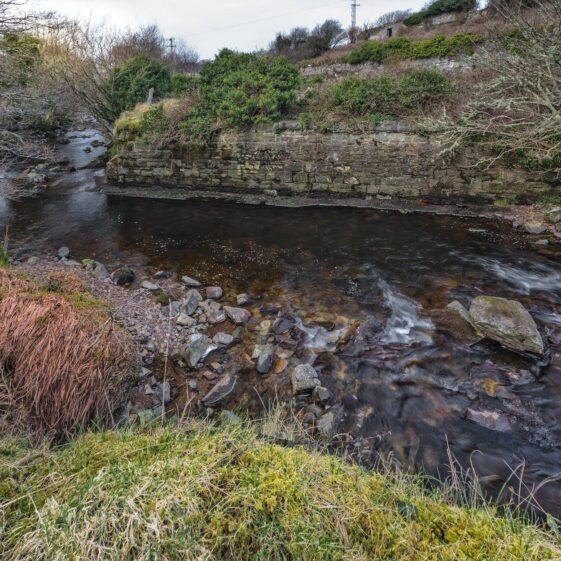 The remains of the bridge ramparts that carried the line over the Oewenglin river. Lat / Long: 53° 29' 12.84'' N, 10° 0' 38.16'' W.
What3Words: ///listed.entitle.first.
Eircode: none available. | Roger Harrison